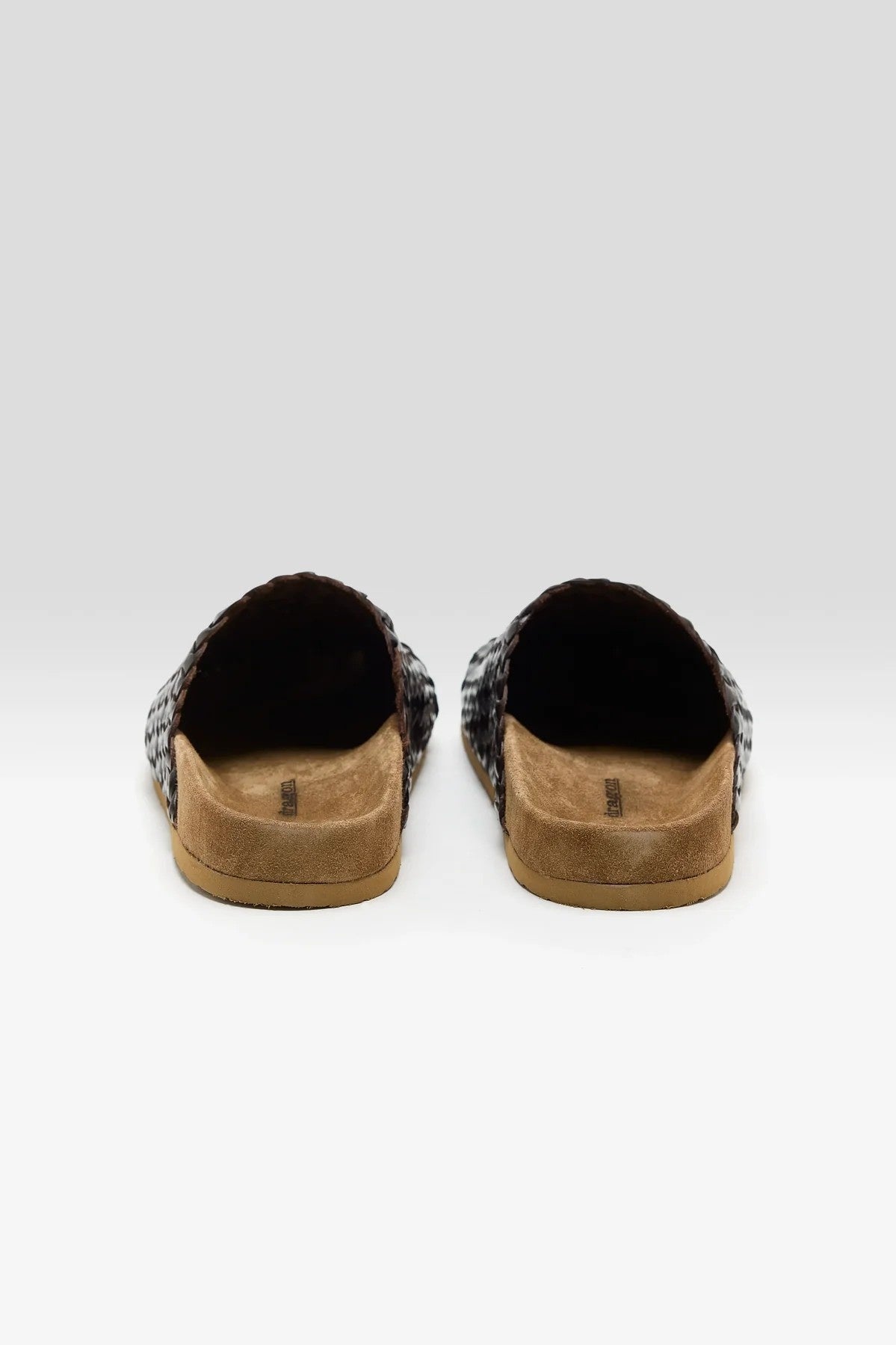Pair of brown shoes with brown soles on a white background
